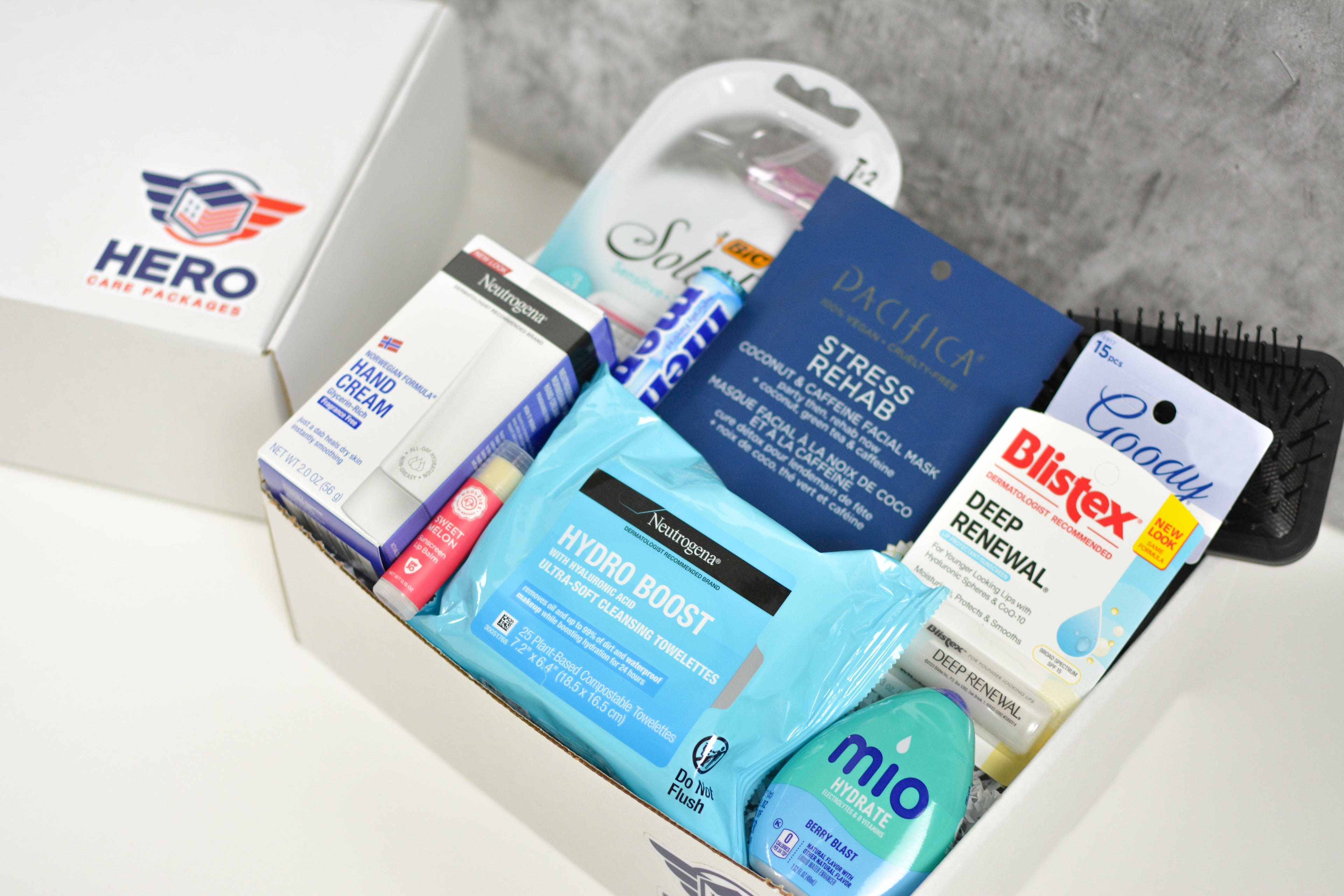 Contents of the Her Call of Duty care package including hand cream, lip balm, cleansing towelettes, and hydration concentrate for deployed women