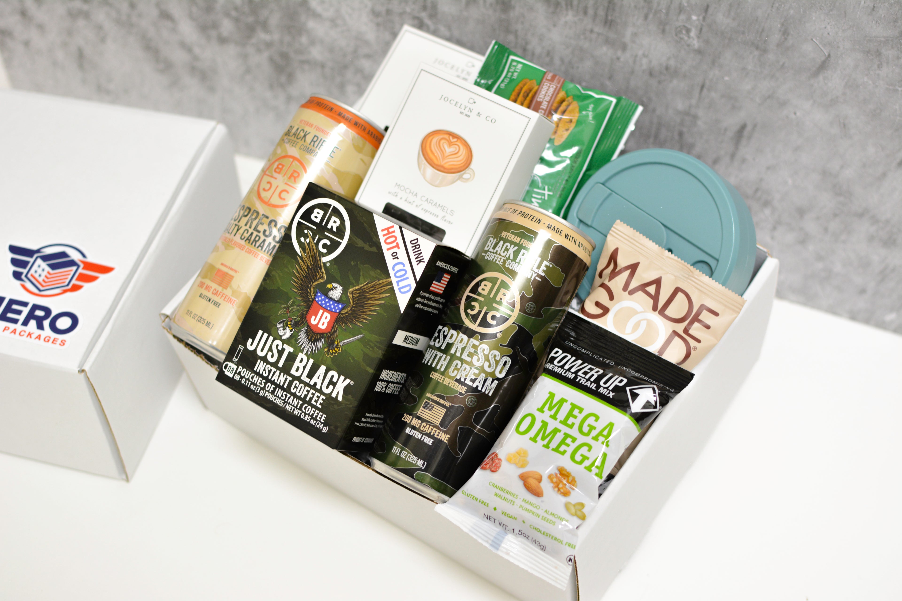 Close-up of military care package featuring Black Rifle Coffee, mocha caramels, collapsible cup, and high-energy snacks for early mornings on deployment