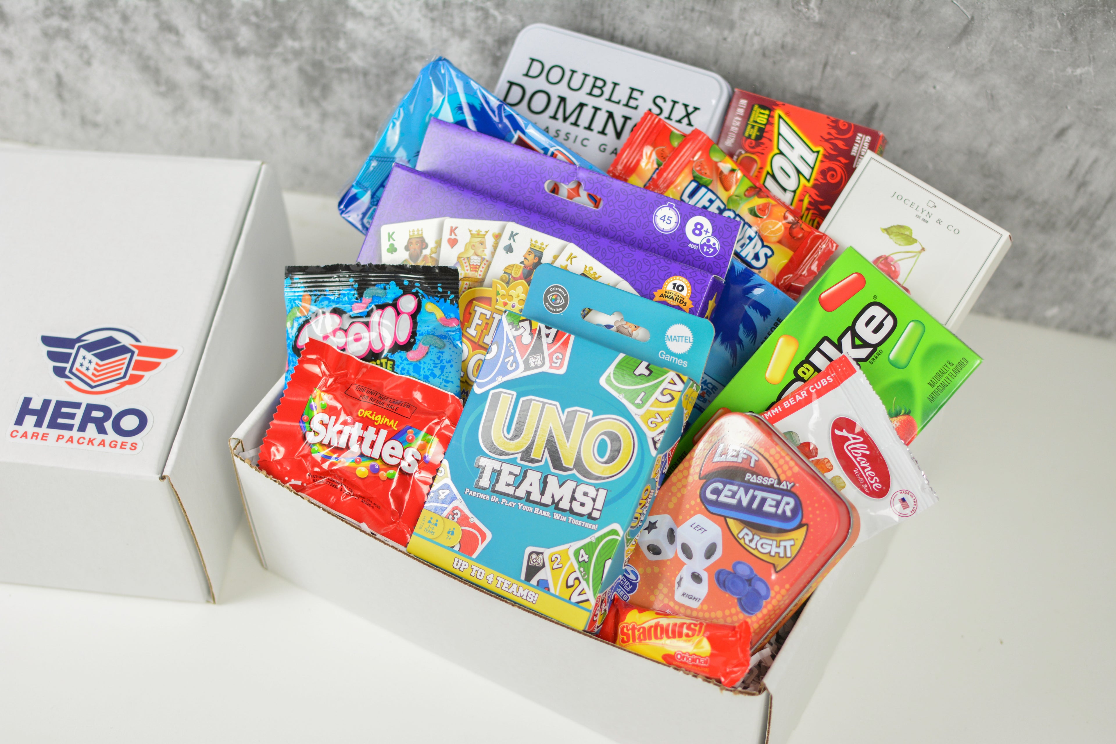 Close-up of military care package including UNO, playing cards, dice games, and snacks designed to bring deployed troops together during downtime