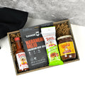 Gift box with spicy food products including Tapatio hot sauce, Cholula sauce, and Habanero Mojo jerky.