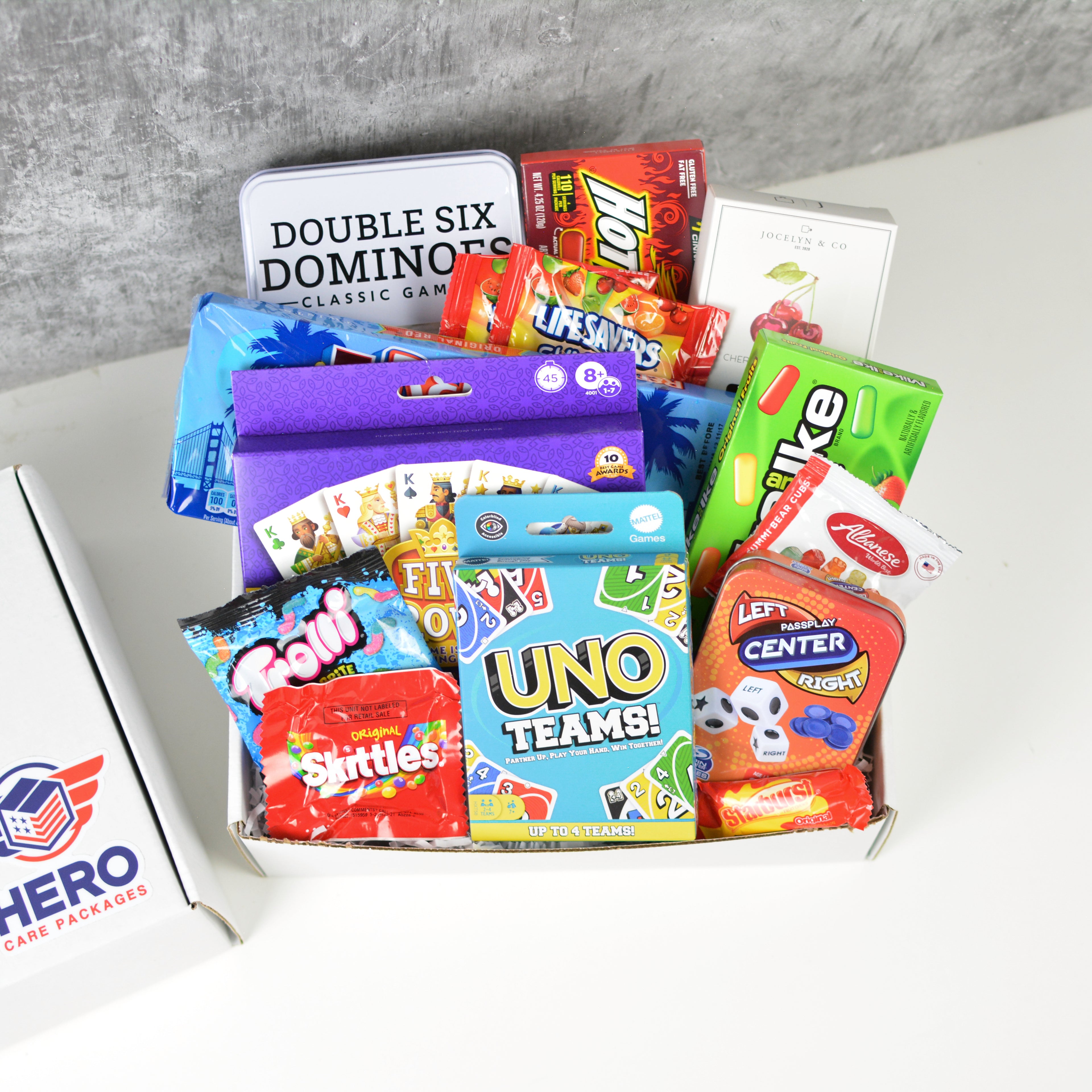 Strategic Play Military Care Package with games and snacks arranged in a gift box for deployed service members