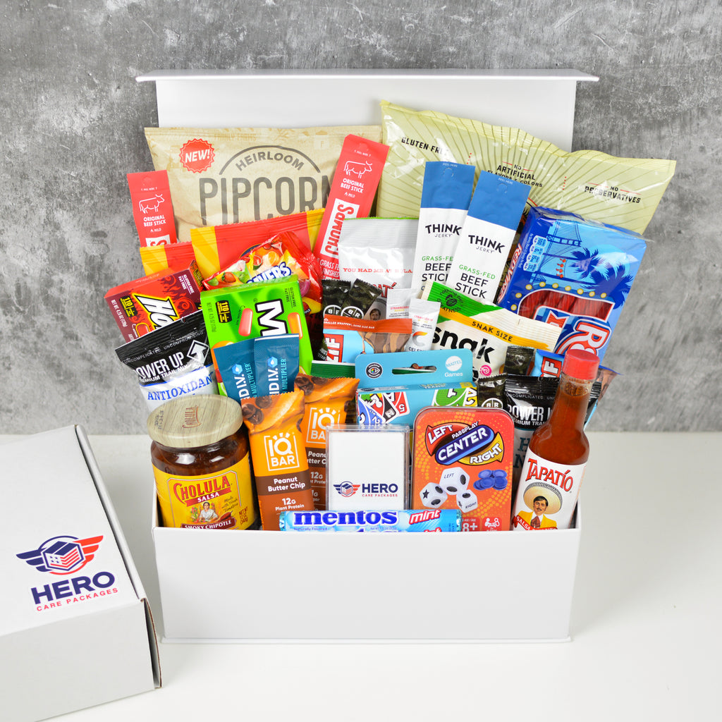 The Entire Troop Military Care Package shown with snacks and games arranged in a large gift box for deployed military units