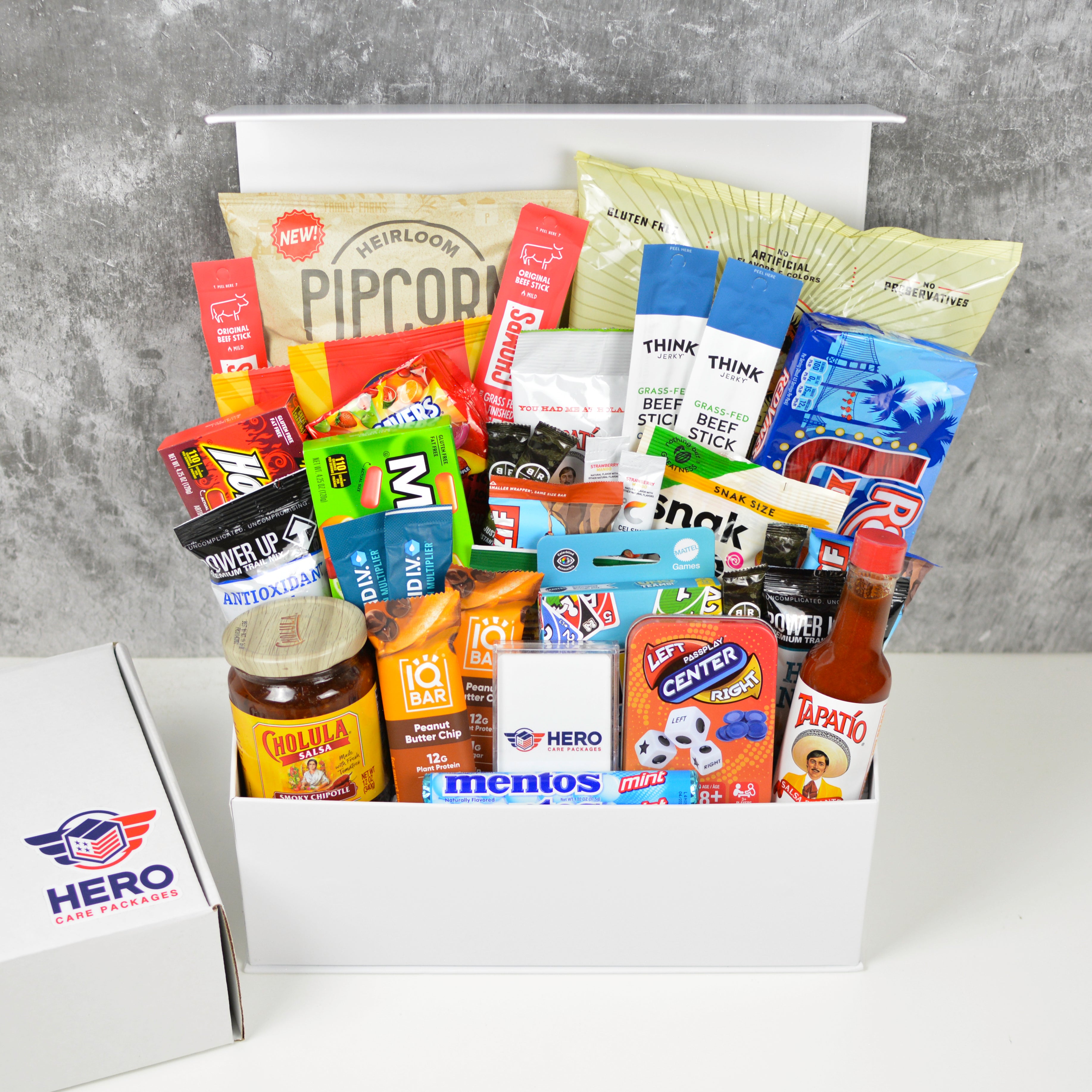The Entire Troop Military Care Package shown with snacks and games arranged in a large gift box for deployed military units
